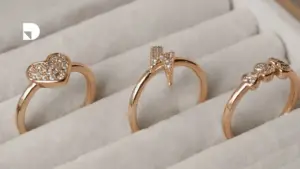 3 anillos con diferentes figuras ubicados en una tienda de joyas