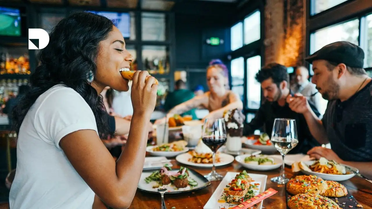 Grupo de amigos comiendo en un restaurante comiendo diversos platos de comida