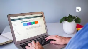 Persona viendo su computador viendo las métricas del sitio web en busca de mejorar la tasa de conversión de las personas que ven y terminan haciendo clic en la página